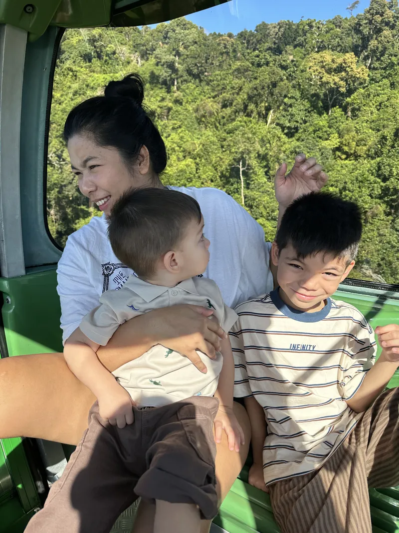The woman and the boys grinning in the gondola