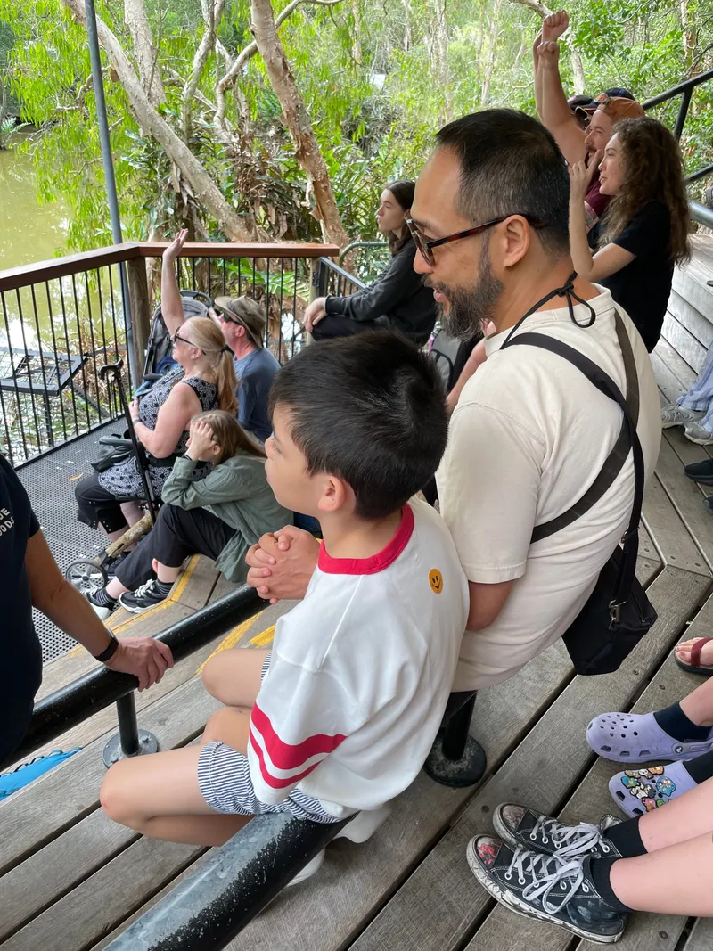 A man and a boy in the stands at the crocodile show