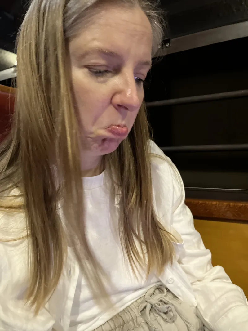 A woman pulling a sad face on the train