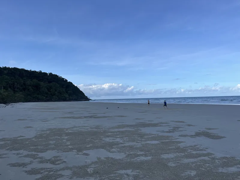 The wide flat beach and the headland, with two people far off