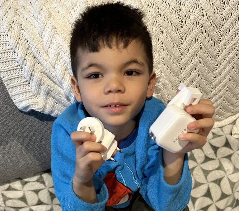 Jaxon holding up two travel chargers