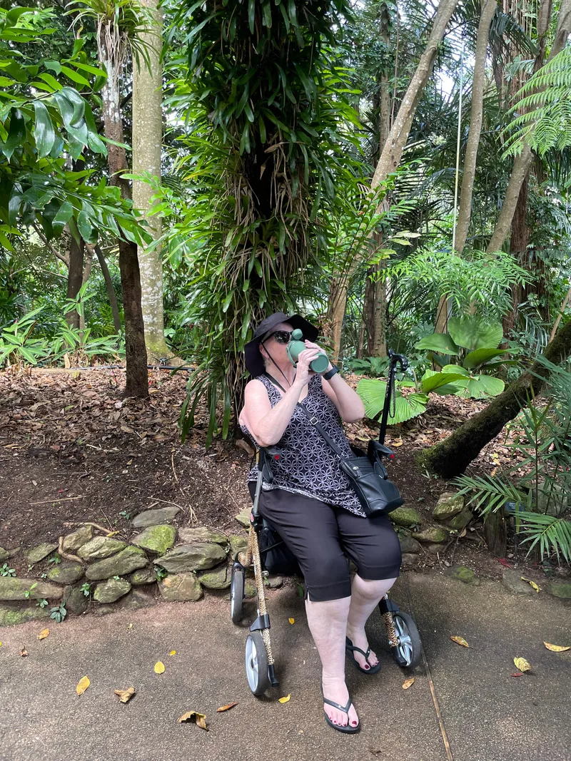 A woman resting on her walker among the trees