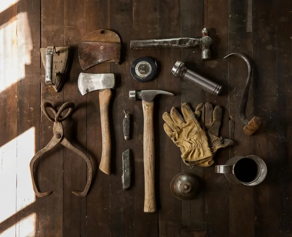 Old hand tools laid out on a wooden table