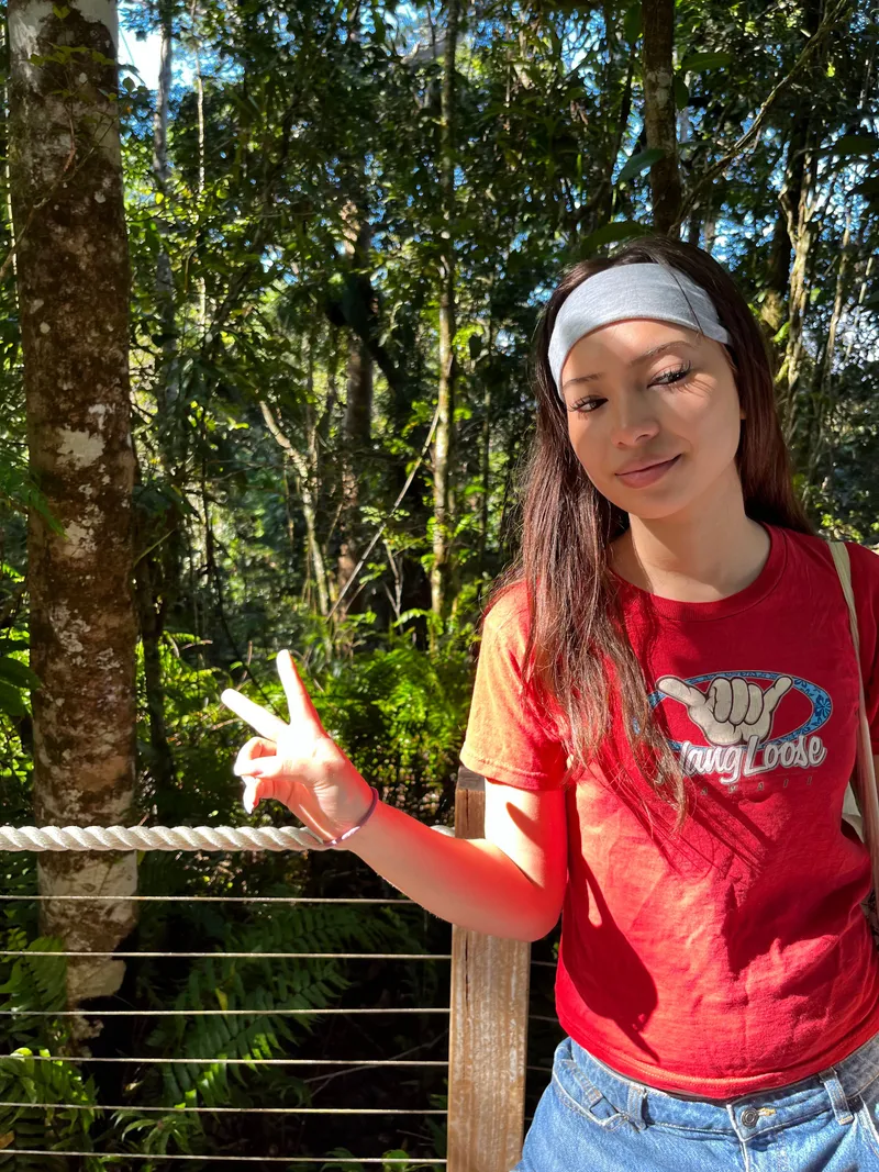 A girl making a peace sign on the boardwalk