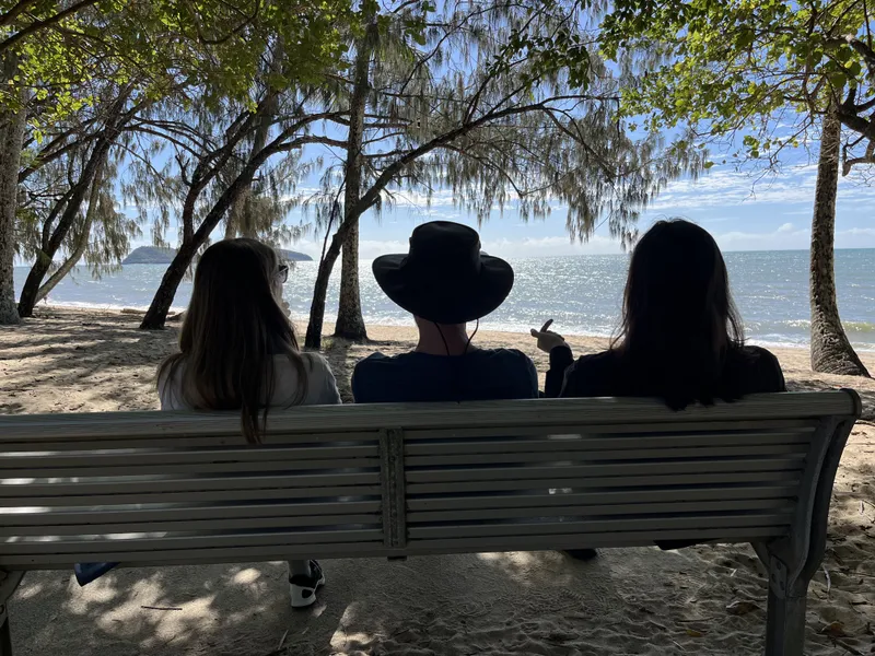 The three on the bench from behind, looking out to sea