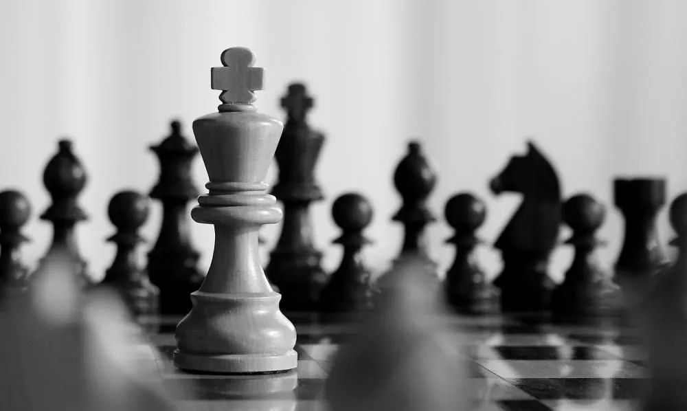 A white chess king among black pieces
