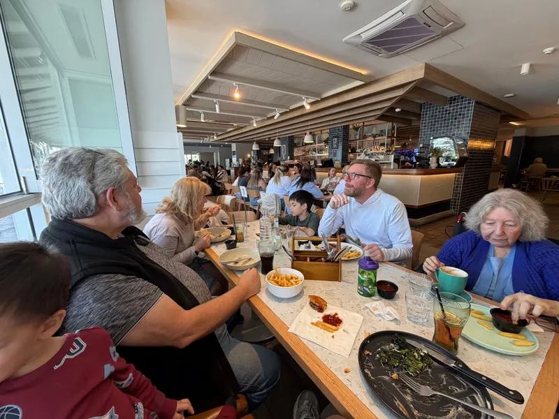 The family around a long table by the windows in a busy restaurant