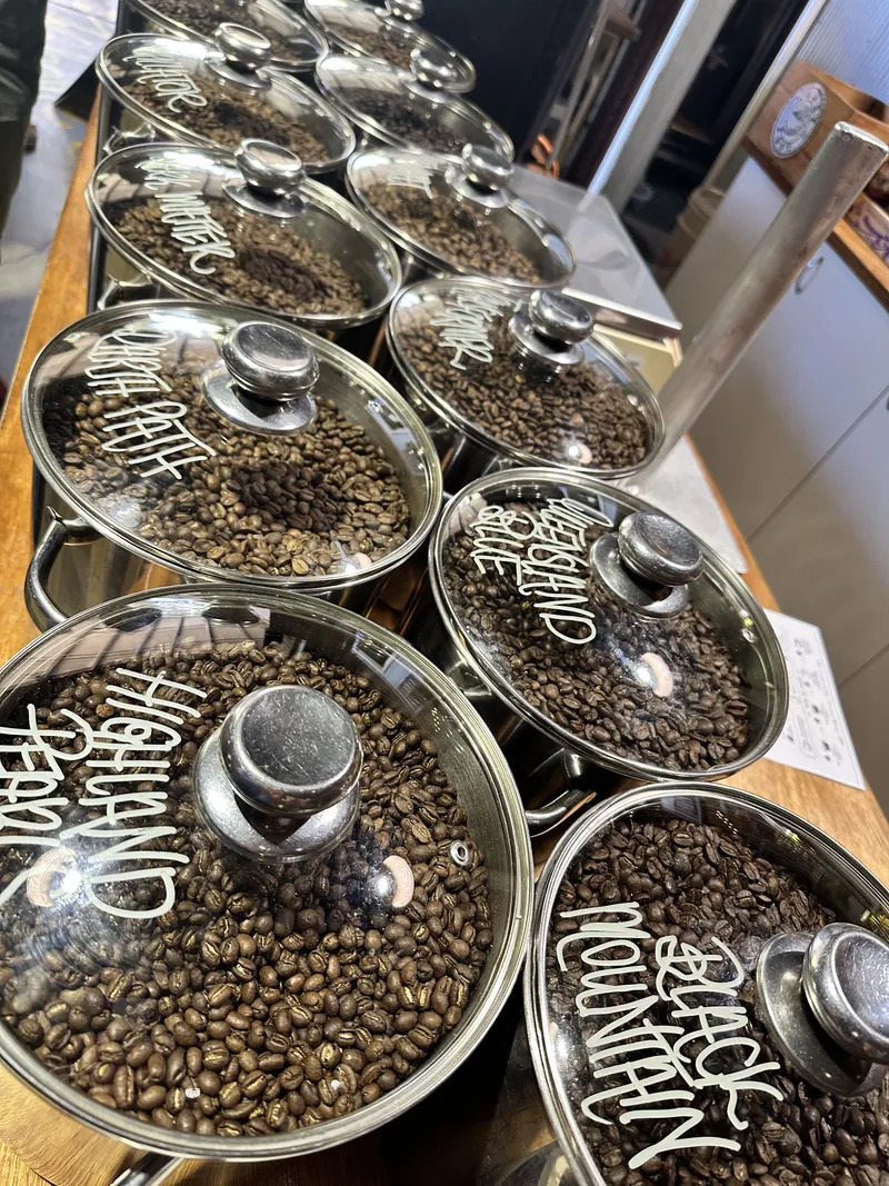 Glass jars of coffee beans labelled Highland Pearl, Black Mountain and more