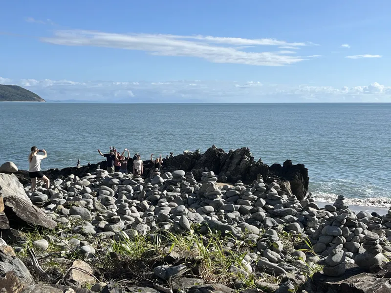Stacks of stones on the rocky point at Rex Lookout, with the coast beyond