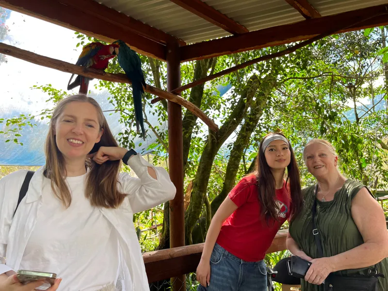 Three women laughing under the macaws