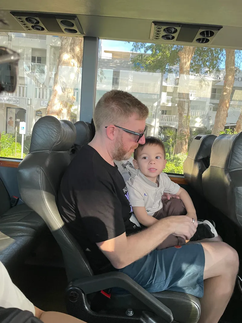 A man with a toddler on his lap on the bus