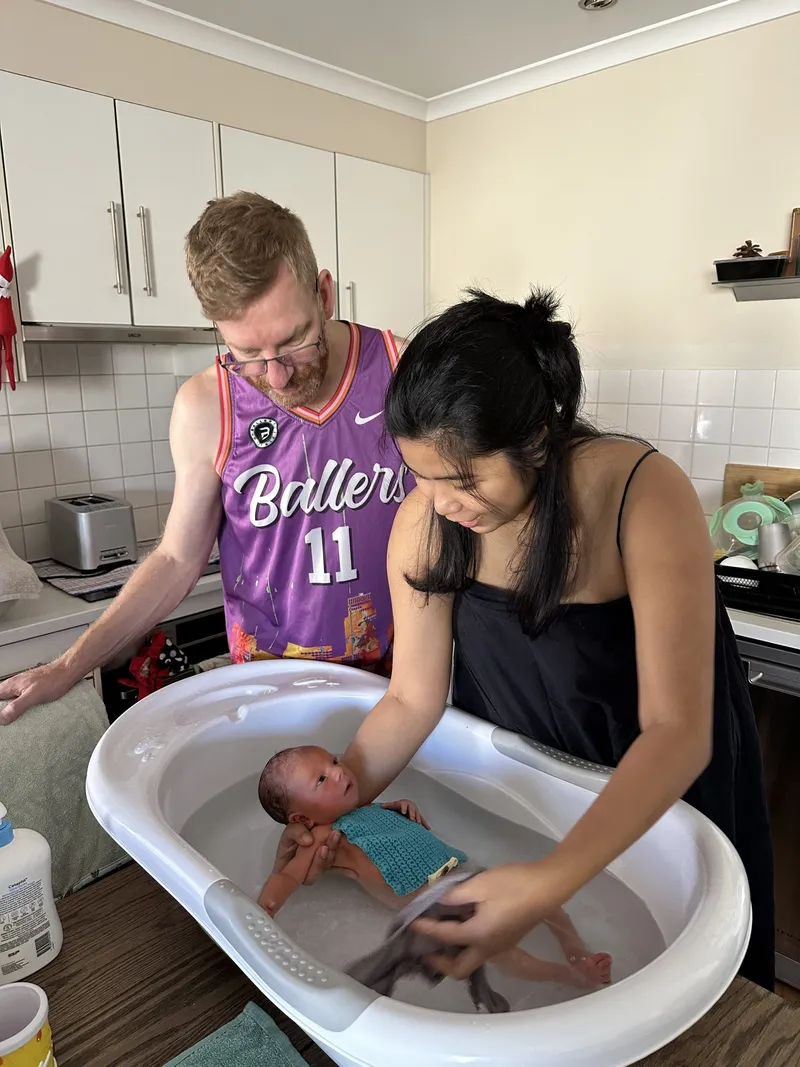 Chris and Ericka giving newborn Ethan his first bath