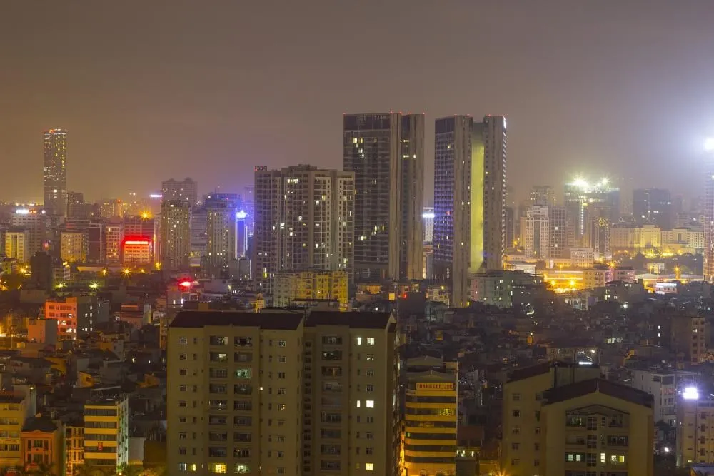 A city skyline of tall buildings lit up at night