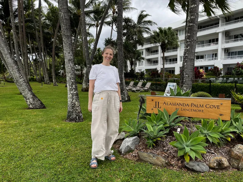 A woman standing in the foreshore gardens under the palms