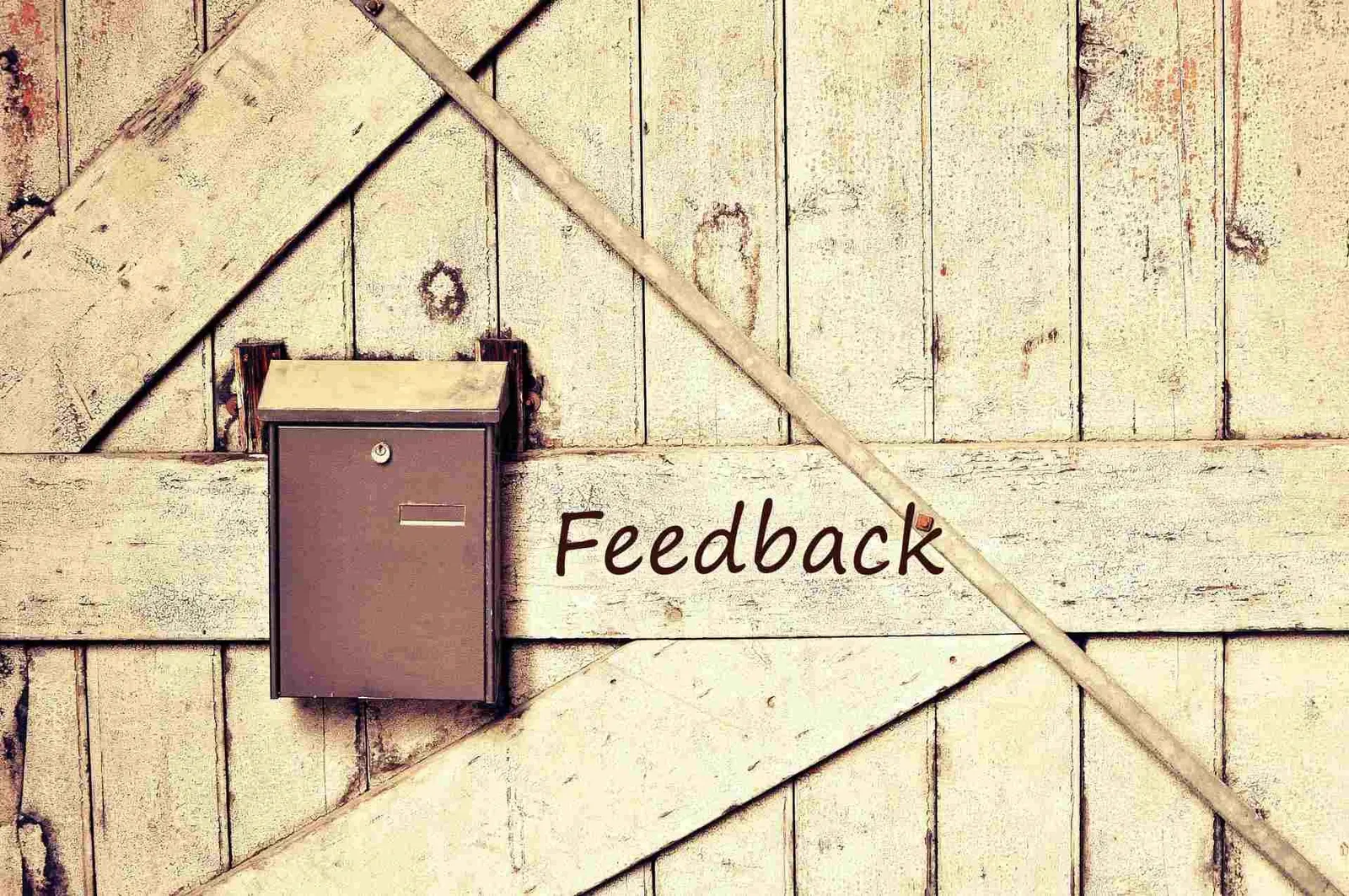 A wooden door with a mailbox and the word Feedback