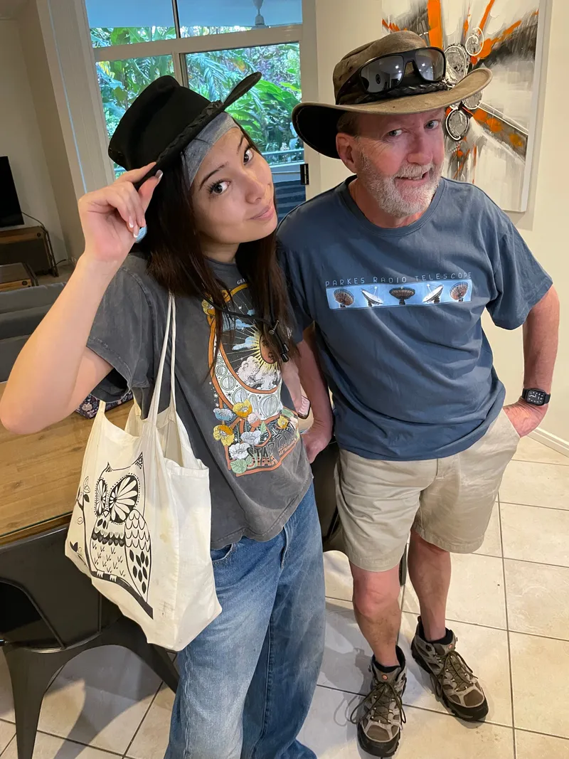 A young woman and a man in a bush hat posing in their hats inside before heading out