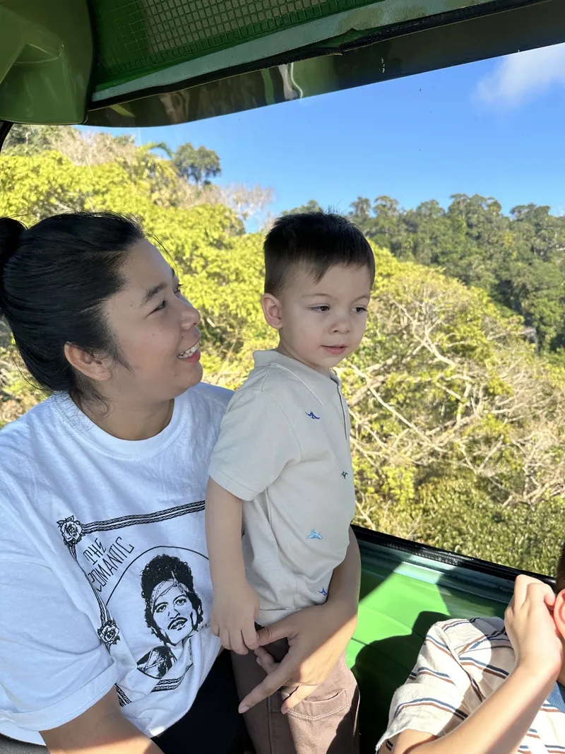 The toddler standing at the window beside the woman