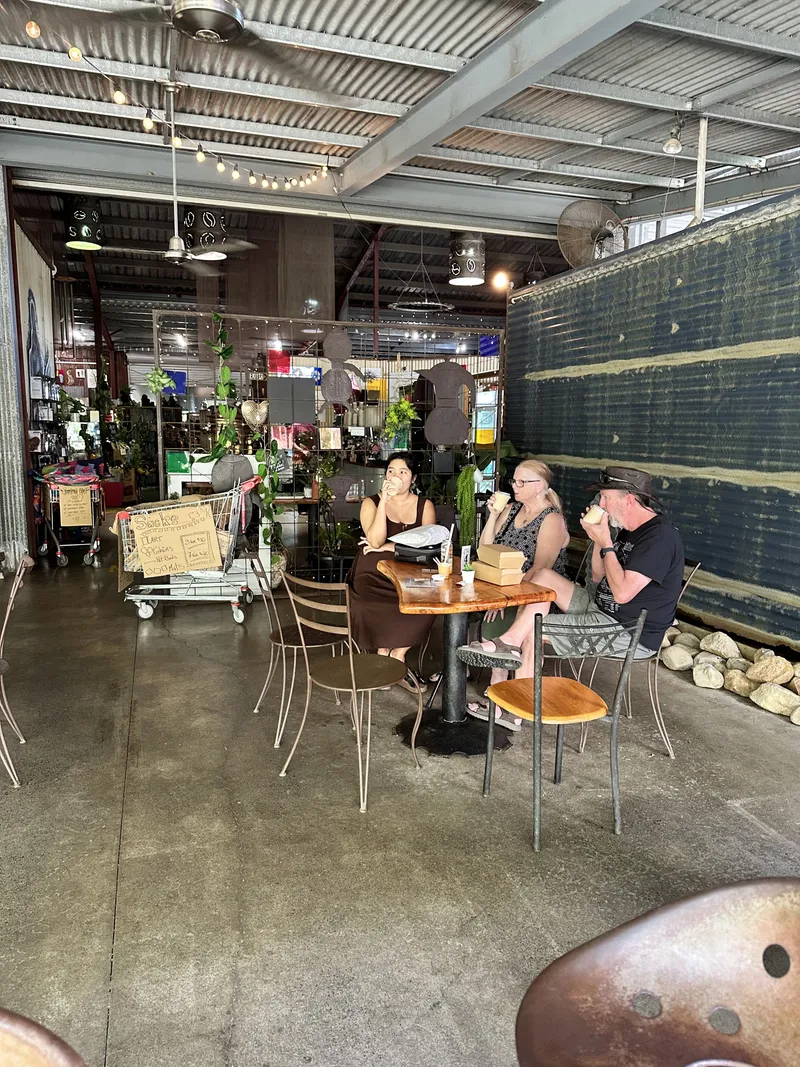 Three people at a table in the open-sided cafe shed