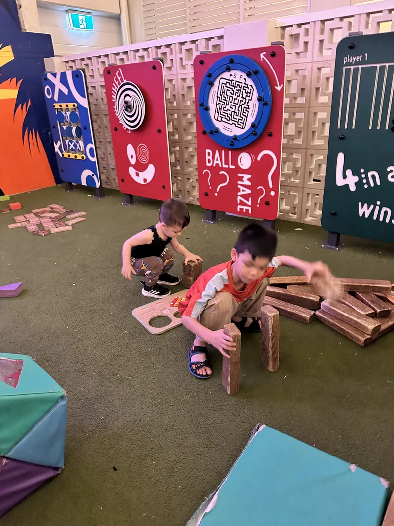 Two boys building with wooden blocks in an indoor play area