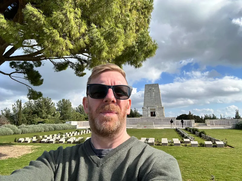 Chris in sunglasses taking a selfie in front of the Lone Pine memorial