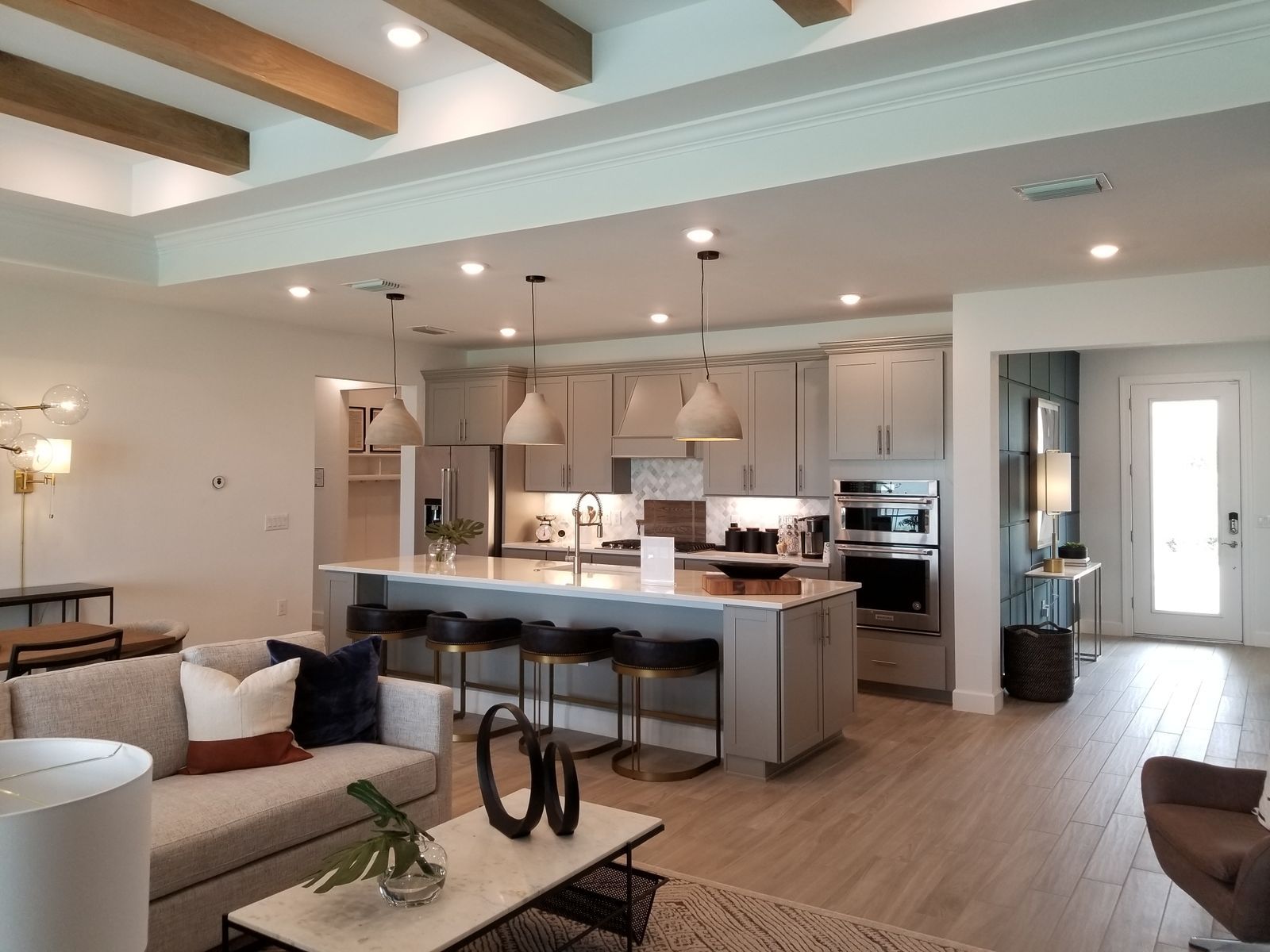 Open-plan living room and kitchen with high ceilings and light wood beams