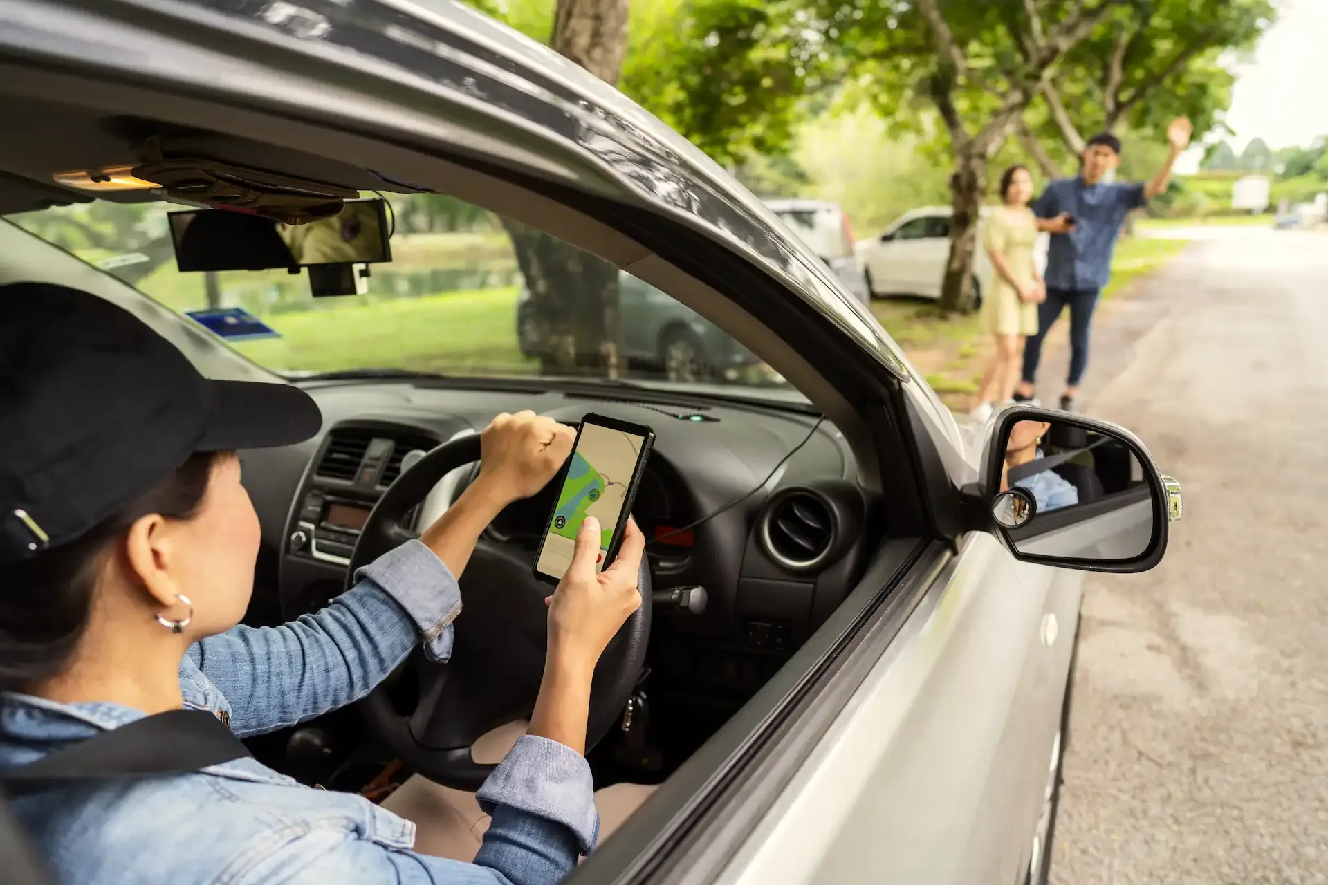 Rideshare driver using a smartphone navigation app while picking up passengers