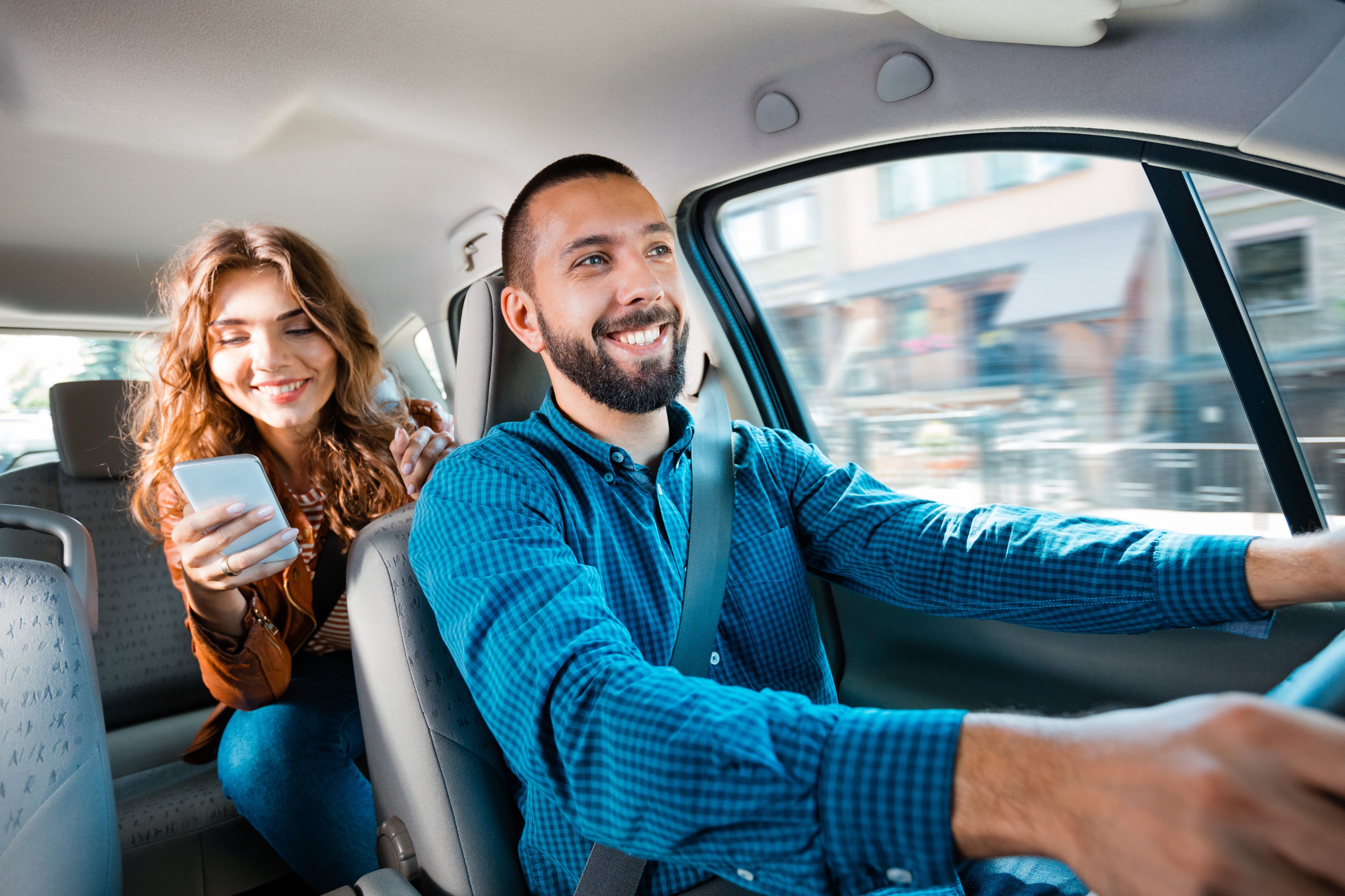 Rideshare driver transporting a passenger using a smartphone during the trip