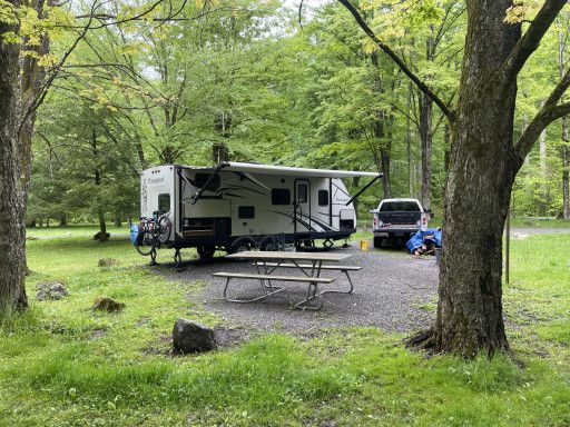 Travel trailer set up at a wooded campground