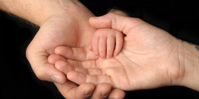 Baby holding an adult's hand