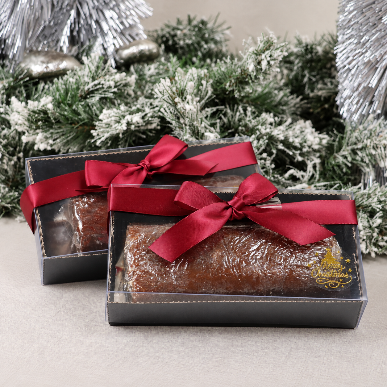 Cajas navideñas de regalo con rollo de ate de guayaba moño rojo y detalle de Merry Christmas en dorado