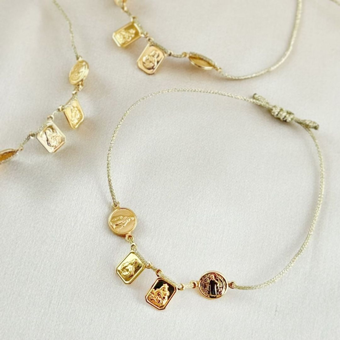 Pulseras de hilo dorado con medallas religiosas y escapularios dorados