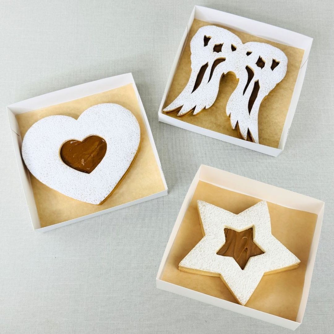 Juego de galletas rellenas con dulce de leche en forma de corazon estrella y alas de angel