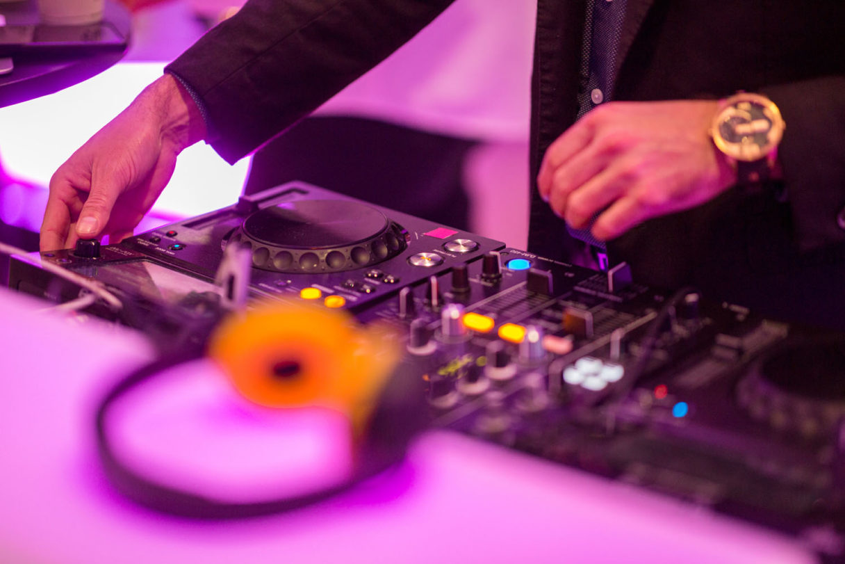 DJ käyttää miksauspöytää ja ohjaa musiikkia tapahtuman tunnelmavalaistuksessa.