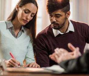 Jeune couple signant une offre d'achat immobilière