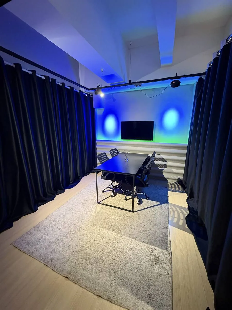 Set de gravação com mesa e iluminação cênica azul