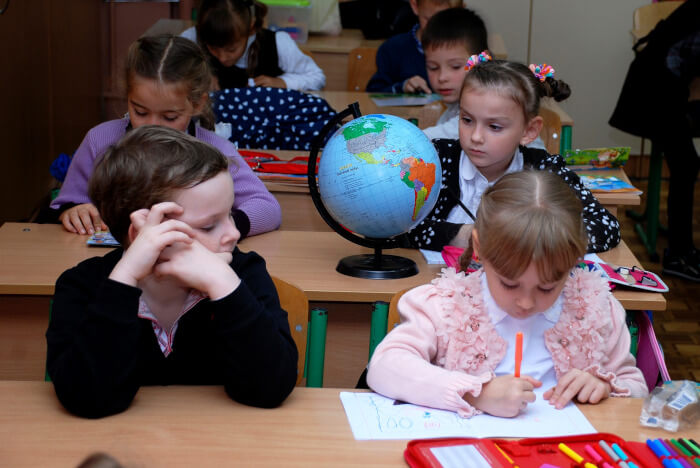 students working on a geography assignment with a globe on a desk