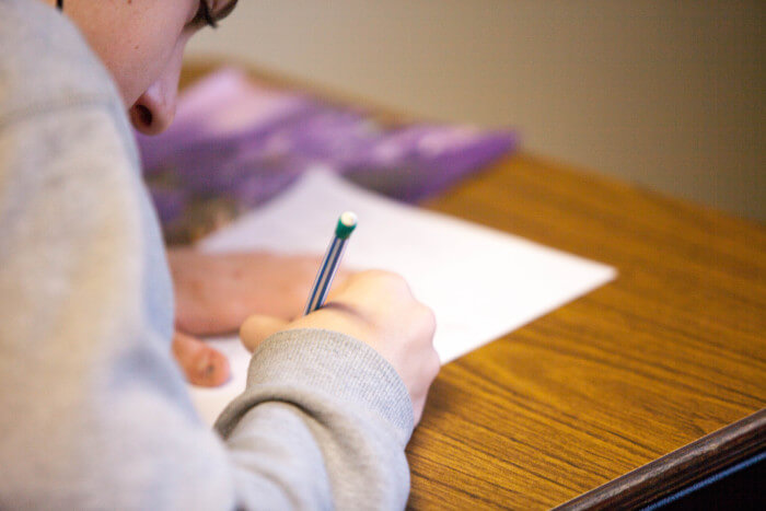 girl writing on a notebook on her desk