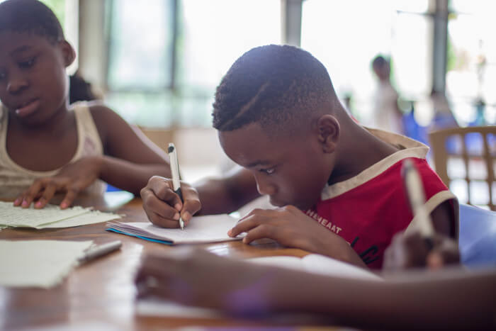 Studying boy with pen writes on paper