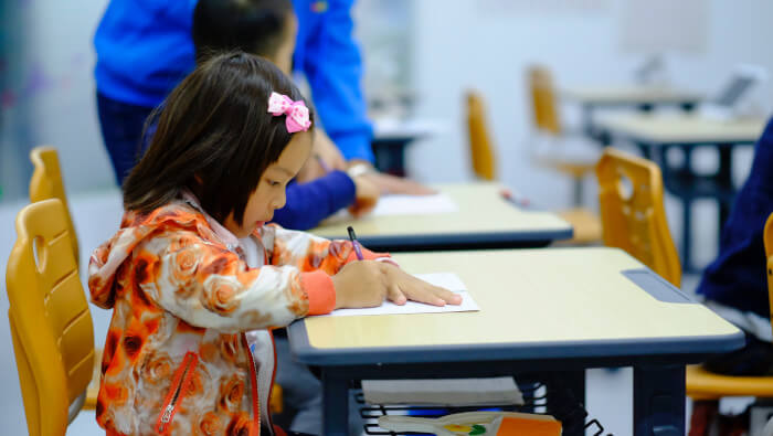 Young girl studying at her school desk