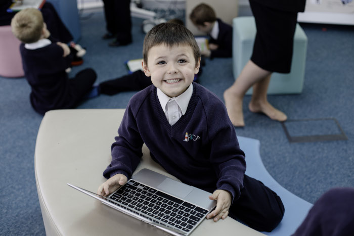 Small boy smiling with computer in his hands