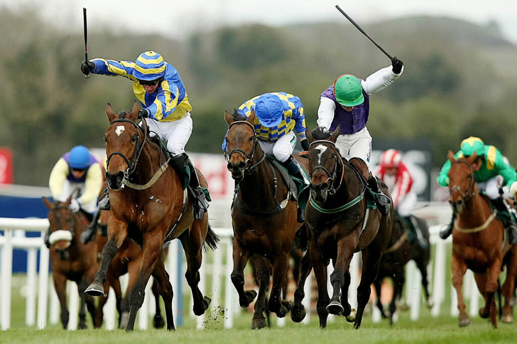 Jockeys using whip from above their shoulder during a race