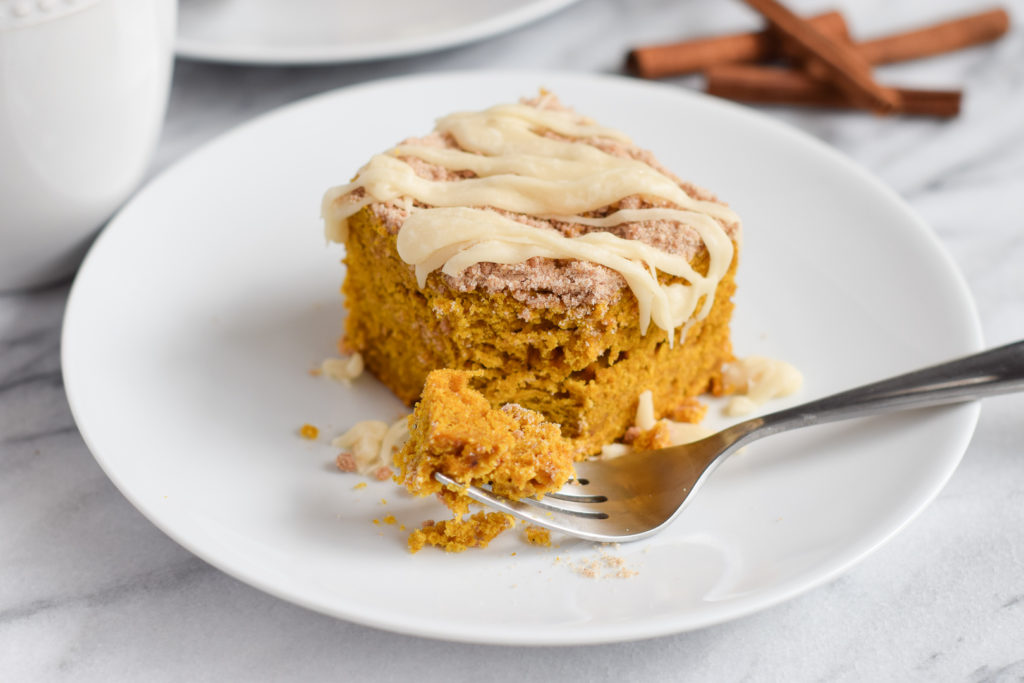 Piece of Cinnamon Streusel Pumpkin Coffee Cake with Cream Cheese on a plate with a fork