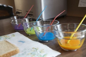 In 4 small bowls, combine milk and food coloring to create your "paint".