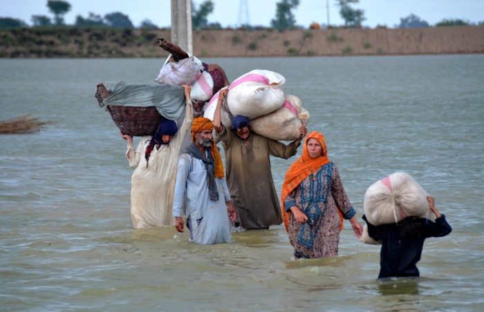 A displaced family wades through a flooded area in Jaffarabad, in Pakistan’s southwestern Baluchistan province, Pakistan.