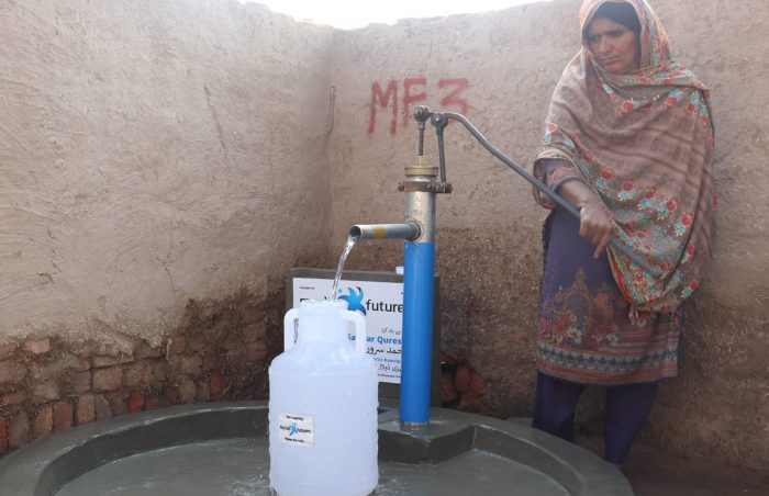 A hand water pump installed in southern Punjab, Pakistan to a door and needy family, with washpad and waterbottle.