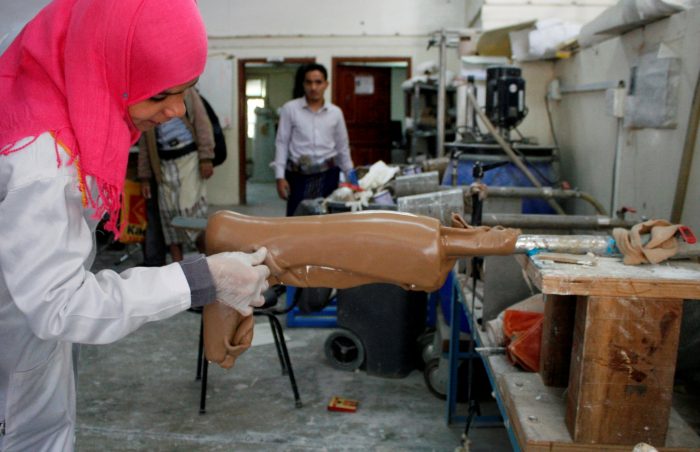 Young lady in pink headscarf, working on prosthesis manufacturing in Yemen