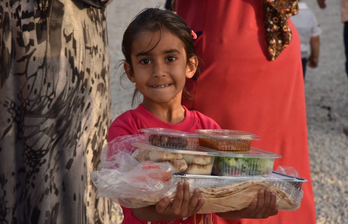 Pretty syrian girl gets cooked pre-packed food in Lebanon.