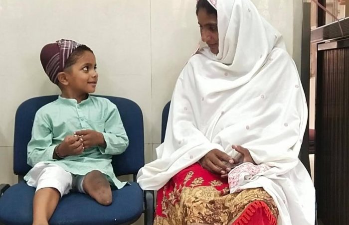Mother with her young son in Pakistan as they await prothesis therapy