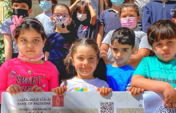 School children in Ramallah, Palestine hold aloft a cheque from Muslim Futures