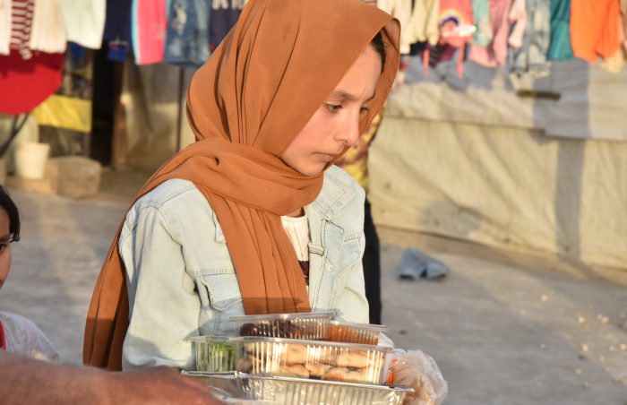 Young Syrian lady walks away with her prepacked cooked food in the Refugee camps of Lebanon